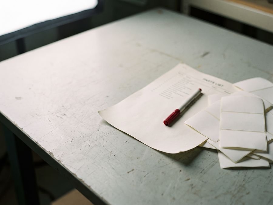 Reference labels and a printed parts list on a workbench
